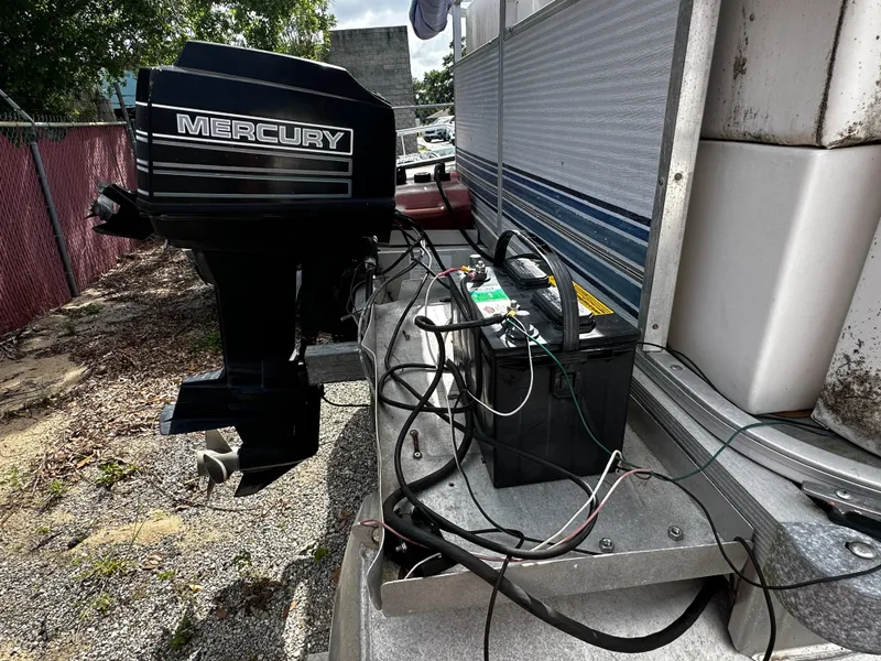 Slide: The Image of 1994 Sylvan Adventure boat with Mercury outboard motor and battery setup. - 4