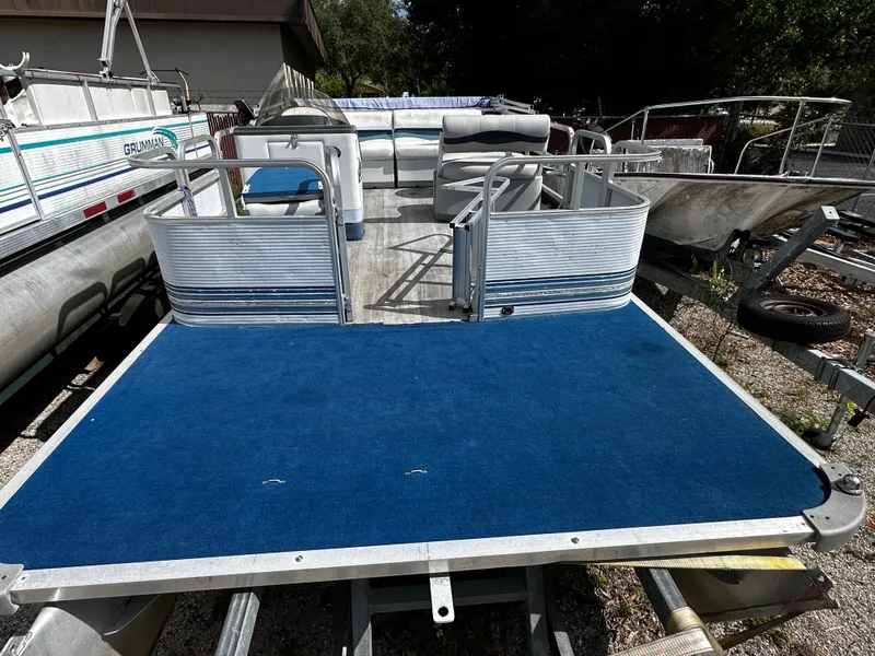 Slide: The Image of 1994 Sylvan Adventure pontoon boat with blue carpet and open deck layout. - 6