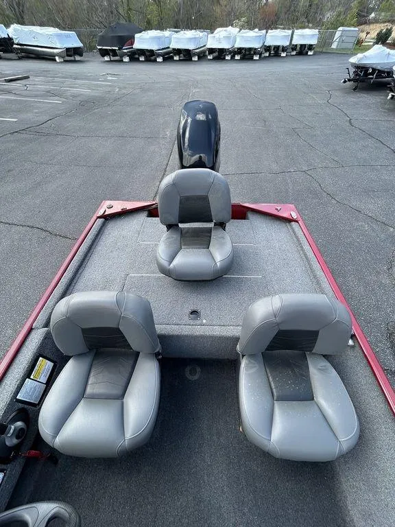 Slide: The Image of 2023 Tracker BASS TRACKER® Classic XL boat with three gray seats in a parking lot. - 4