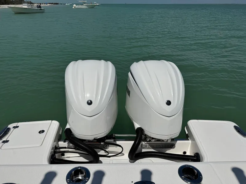Slide: The Image of 2022 Robalo R272 Center Console boat with dual outboard engines on calm water. - 3