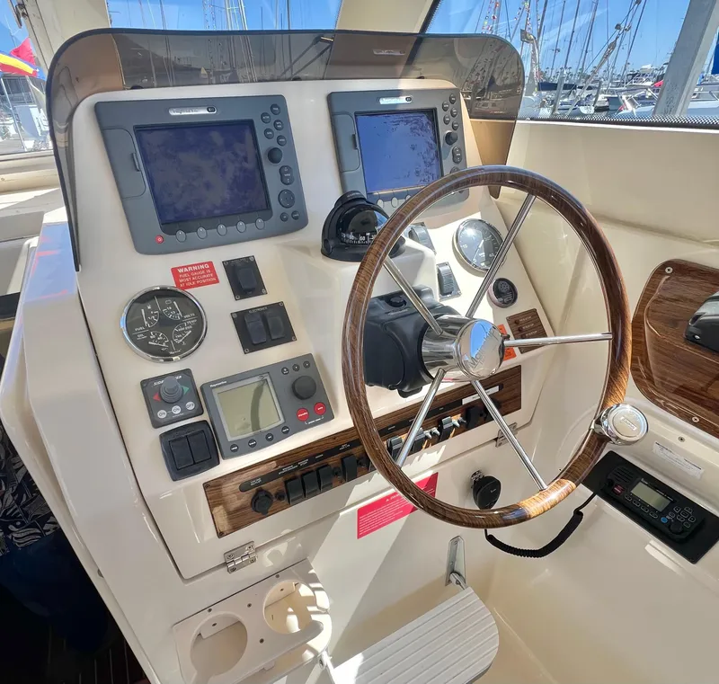 Slide: The Image of 2006 Mainship Pilot 30-II Sedan helm with steering wheel and navigation instruments. - 11