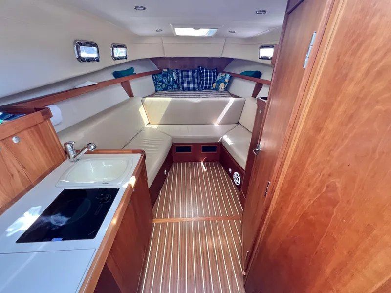 Slide: The Image of 2006 Mainship Pilot 30-II Sedan interior with kitchenette, seating, and wood finish. - 15