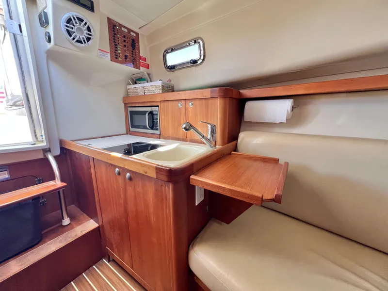 Slide: The Image of 2006 Mainship Pilot 30-II Sedan interior with kitchenette, sink, and seating area. - 17