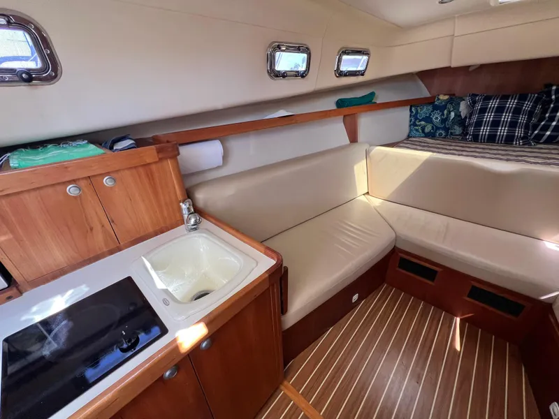 Slide: The Image of 2006 Mainship Pilot 30-II Sedan interior with kitchenette, seating, and bed. - 18