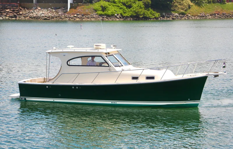 Slide: The Image of 2006 Mainship Pilot 30-II Sedan cruising on calm water, side view. - 2