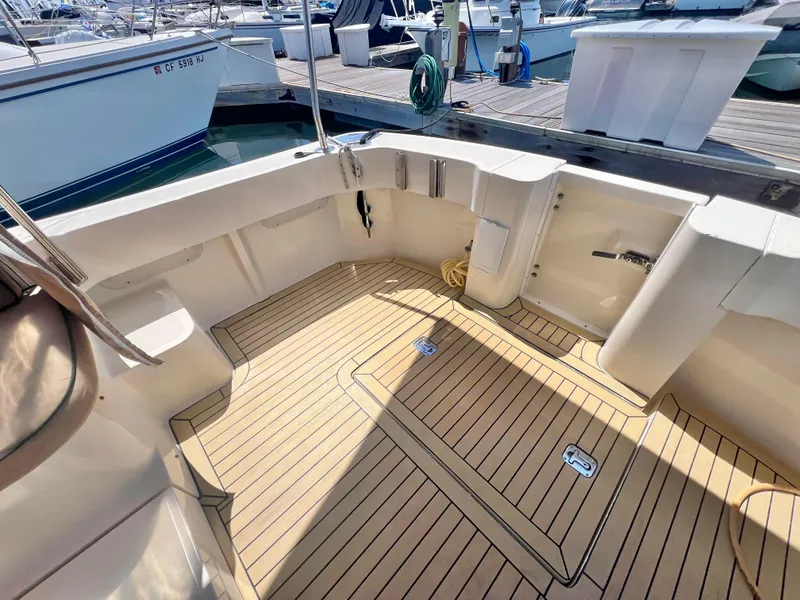 Slide: The Image of 2006 Mainship Pilot 30-II Sedan boat deck with wood finish at marina. - 25