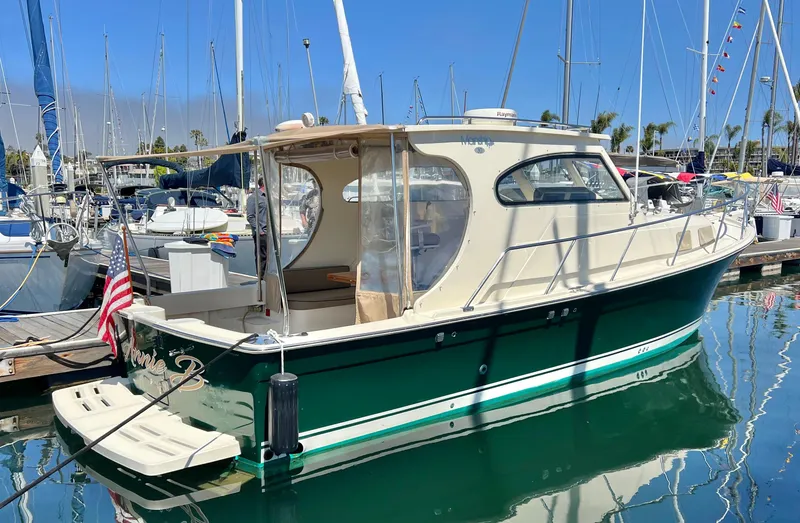 Slide: The Image of 2006 Mainship Pilot 30-II Sedan docked in a marina, featuring a green hull and beige cabin. - 29