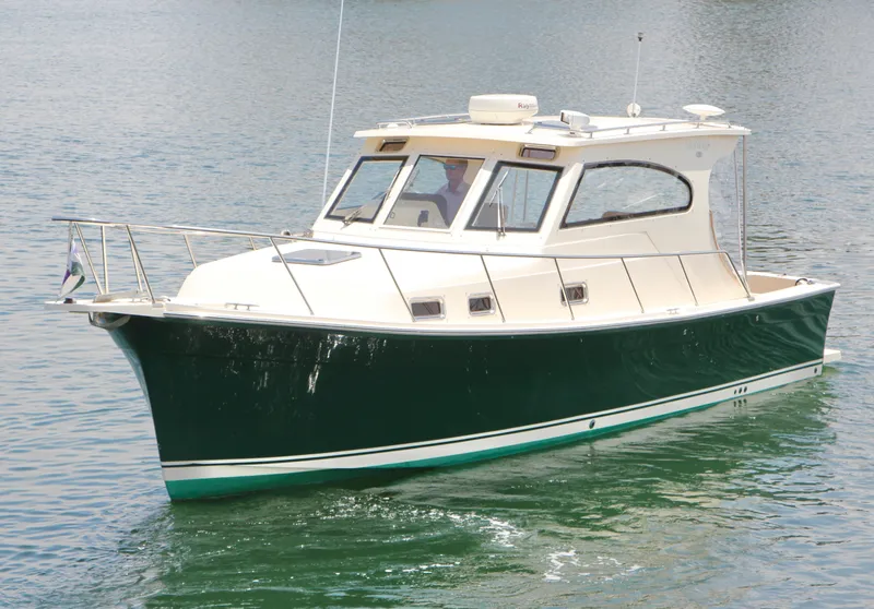 Slide: The Image of 2006 Mainship Pilot 30-II Sedan cruising on calm water, showcasing sleek design and green hull. - 3