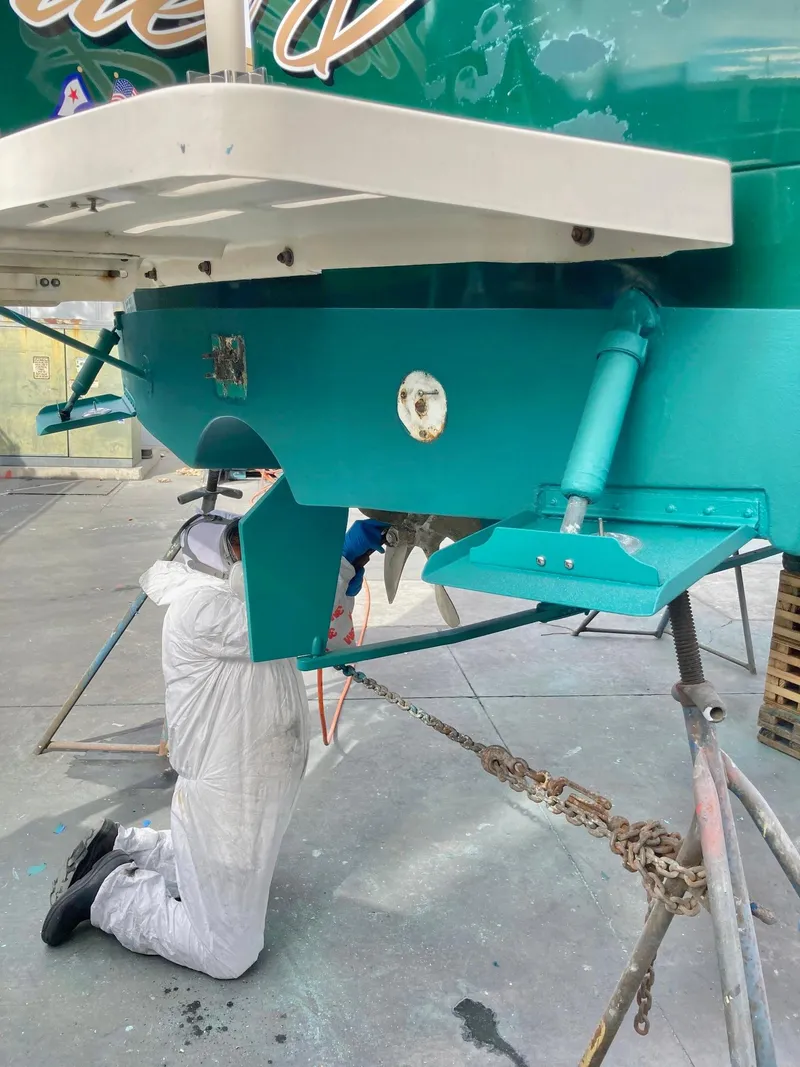 Slide: The Image of Person working on a 2006 Mainship Pilot 30-II Sedan boat hull in a workshop. - 34