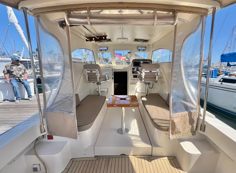 Slide: The Image of 2006 Mainship Pilot 30-II Sedan interior with seating and table, docked at marina. - 6
