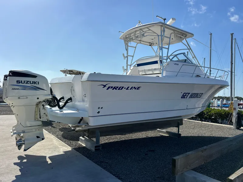Slide: The Image of 1999 Pro-Line 2950 WALK boat with Suzuki outboard motor on display. - 0