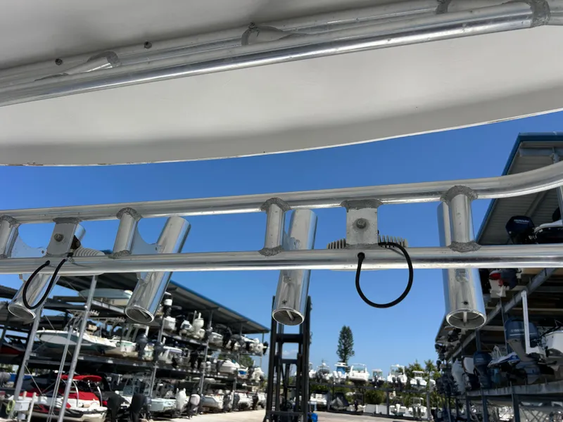 Slide: The Image of 1999 Pro-Line 2950 WALK boat with rod holders, docked in a marina under clear blue sky. - 15