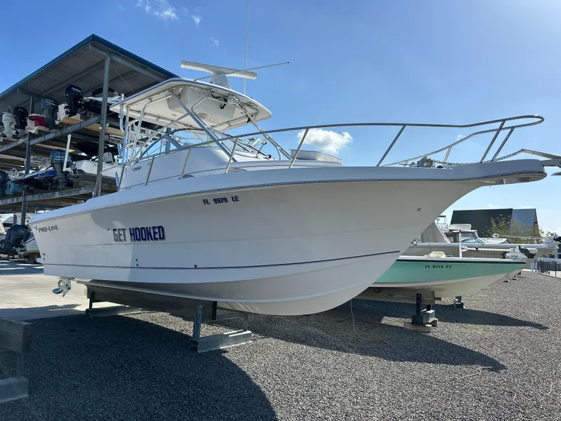 Slide: The Image of 1999 Pro-Line 2950 WALK boat on display in a marina, labeled "Get Hooked." - 2
