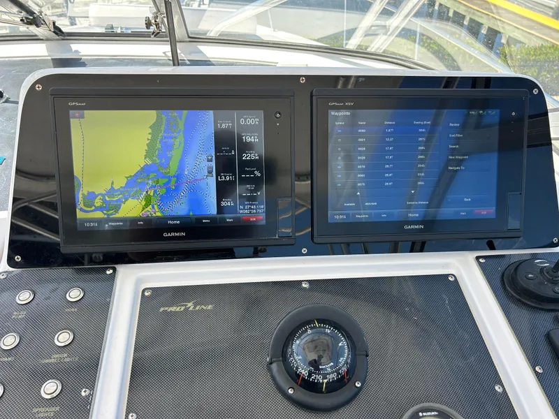 Slide: The Image of 1999 Pro-Line 2950 WALK boat dashboard with Garmin navigation displays and compass. - 21
