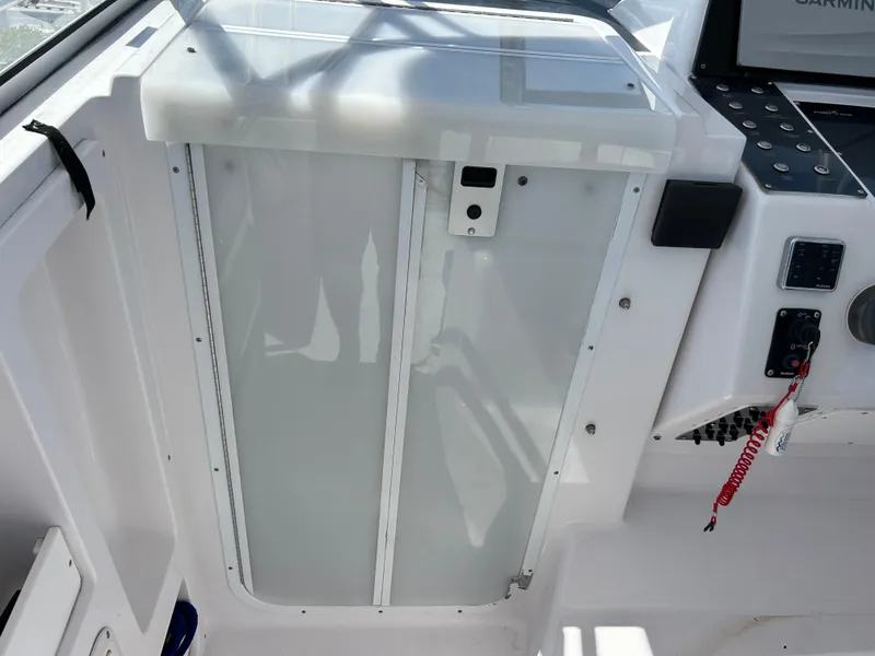 Slide: The Image of 1999 Pro-Line 2950 WALK boat cockpit with control panel and cabin door. - 23