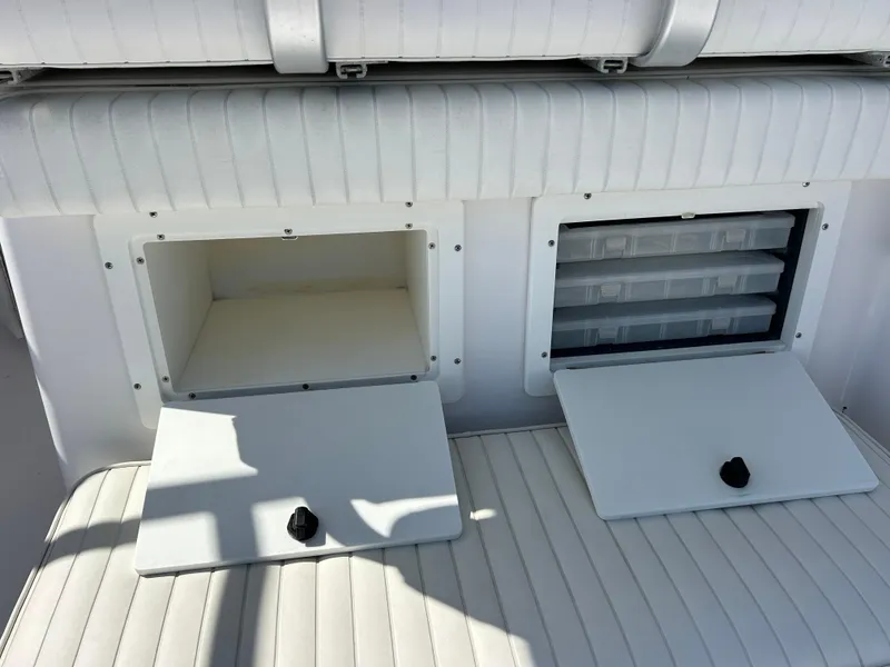 Slide: The Image of 1999 Pro-Line 2950 WALK boat storage compartments with open lids, showcasing interior space. - 43