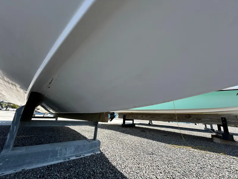 Slide: The Image of 1999 Pro-Line 2950 WALK boat hull on gravel, supported by metal stands. - 5