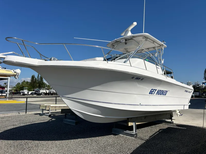 Slide: The Image of 1999 Pro-Line 2950 WALK boat on display, named "Get Hooked," in a marina setting. - 6