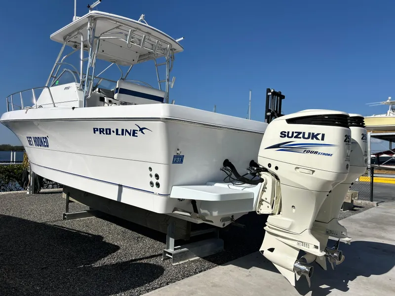 Slide: The Image of 1999 Pro-Line 2950 WALK boat with Suzuki outboard motor, displayed on a trailer. - 7