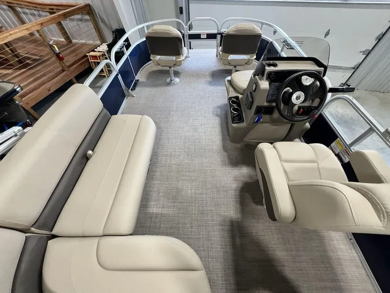 Slide: The Image of 2025 Sun Tracker Bass Buggy® 16 XL Select pontoon boat interior with beige seating and steering console. - 16