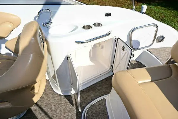 Slide: The Image of 2015 Crownline 236 SC boat interior with beige seating and open storage compartment. - 42