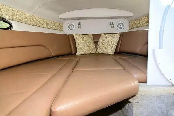 Slide: The Image of 2015 Crownline 236 SC cabin interior with brown leather seating and floral accents. - 13