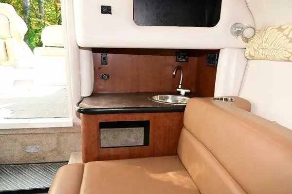 Slide: The Image of Interior of 2015 Crownline 236 SC boat with kitchenette and seating area. - 15