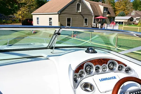 Slide: The Image of 2015 Crownline 236 SC boat dashboard with Lowrance system, near residential homes. - 36