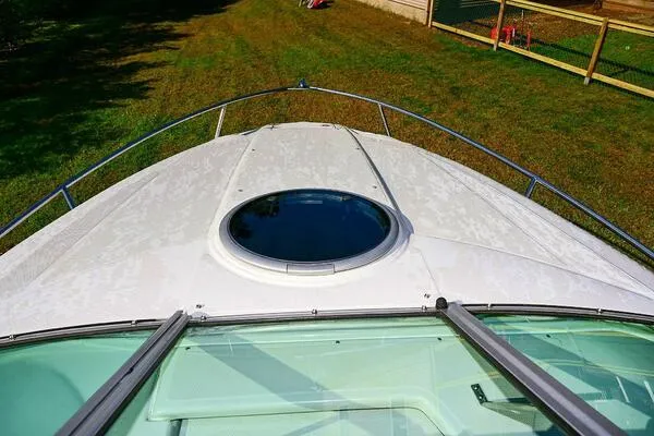 Slide: The Image of 2015 Crownline 236 SC boat deck with circular hatch, grassy background. - 45
