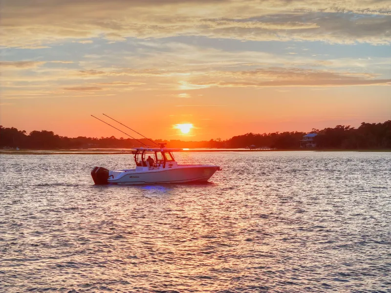 Slide: The Image of 2025 Crevalle 33 CSF boat on water at sunset, serene landscape. - 1