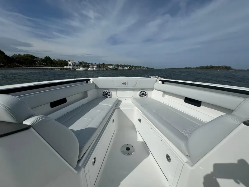 Slide: The Image of 2025 Crevalle 33 CSF boat interior with spacious seating, on a calm waterway. - 10