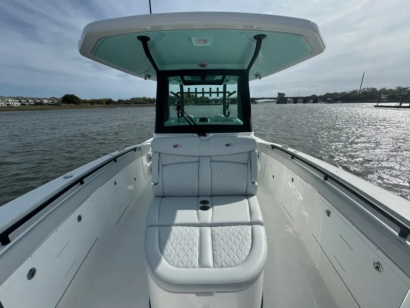 Slide: The Image of 2025 Crevalle 33 CSF boat interior with cushioned seating, on calm water. - 18