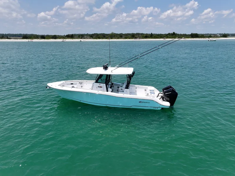 Slide: The Image of 2025 Crevalle 33 CSF boat on clear blue water under a partly cloudy sky. - 2