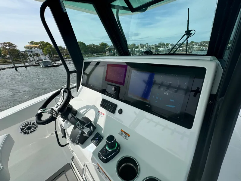 Slide: The Image of 2025 Crevalle 33 CSF boat dashboard with modern navigation controls and steering wheel. - 22