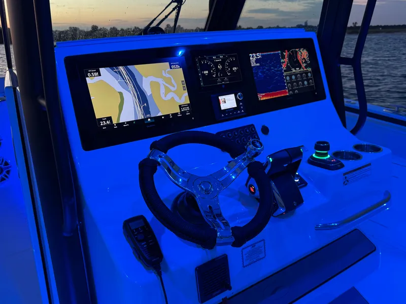 Slide: The Image of 2025 Crevalle 33 CSF boat dashboard with illuminated navigation screens at sunset. - 24