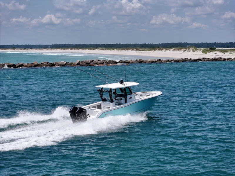 Slide: The Image of 2025 Crevalle 33 CSF boat cruising on blue ocean near sandy shoreline. - 3