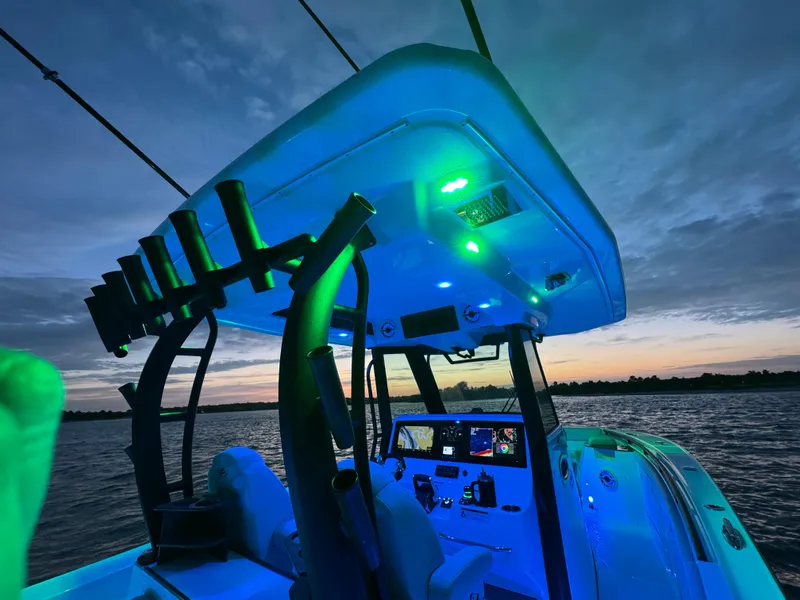 Slide: The Image of 2025 Crevalle 33 CSF boat interior with blue lighting at sunset on the water. - 30