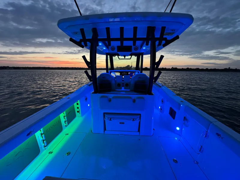 Slide: The Image of 2025 Crevalle 33 CSF boat with vibrant blue LED lights at sunset on the water. - 37