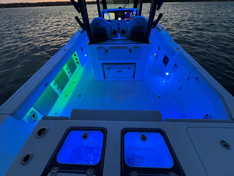 Slide: The Image of 2025 Crevalle 33 CSF boat interior with vibrant blue and green LED lighting. - 39
