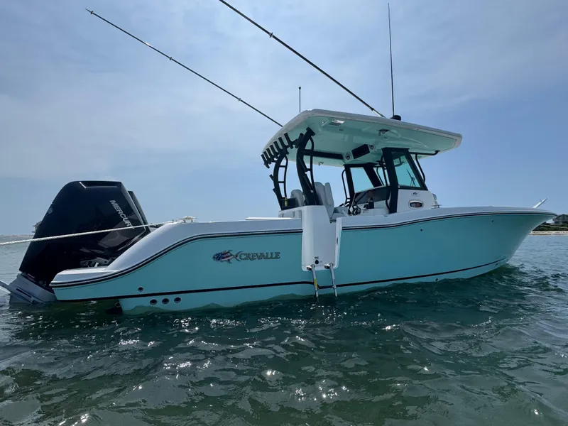 Slide: The Image of 2025 Crevalle 33 CSF boat on water, featuring sleek design and fishing rods. - 4