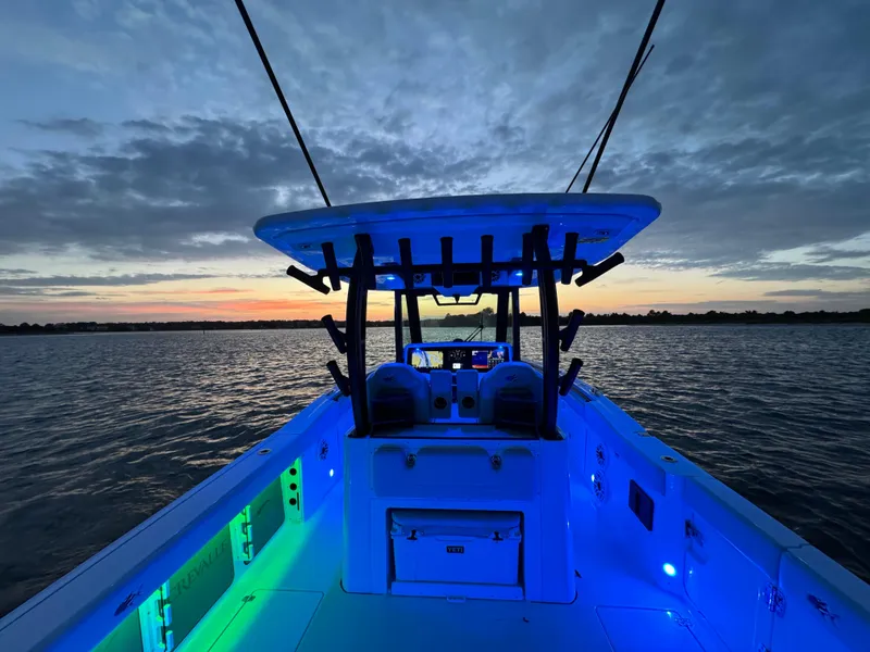 Slide: The Image of 2025 Crevalle 33 CSF boat with vibrant LED lighting at sunset on the water. - 40