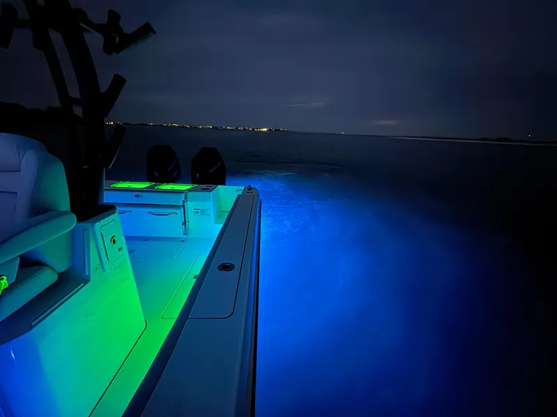 Slide: The Image of 2025 Crevalle 33 CSF boat with glowing blue and green lights on water at night. - 41