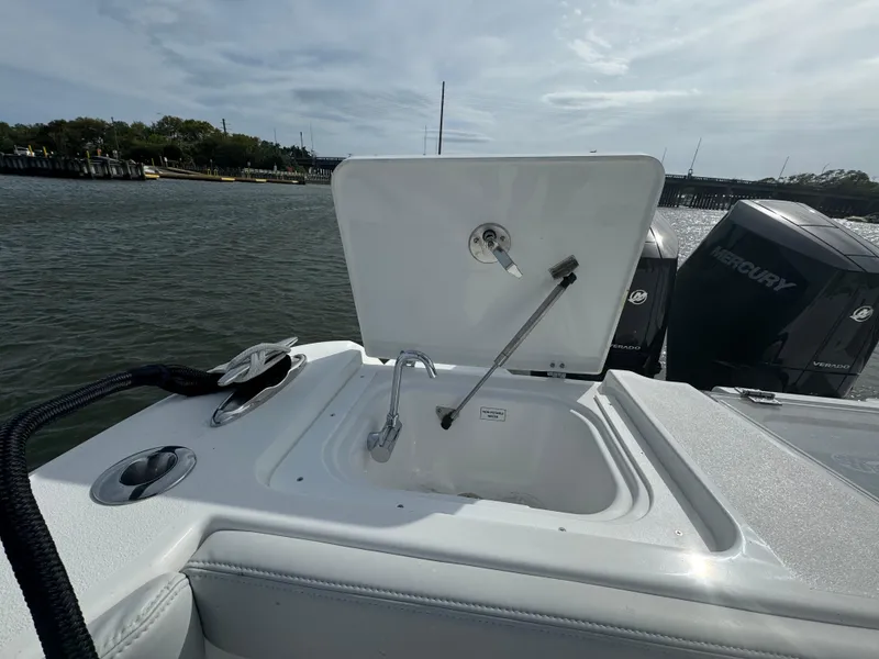 Slide: The Image of 2025 Crevalle 33 CSF boat with open storage compartment, docked by the water. - 43