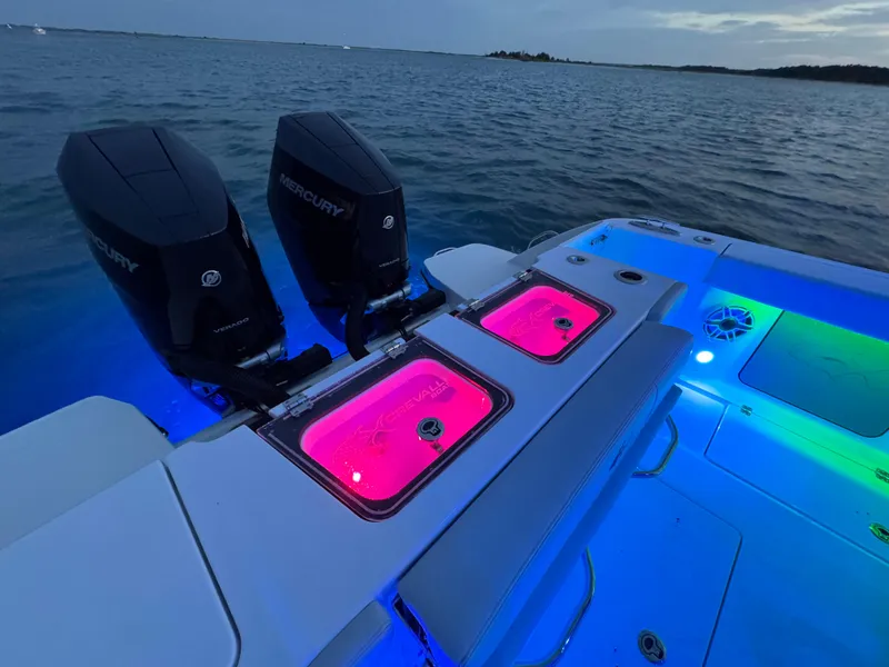 Slide: The Image of 2025 Crevalle 33 CSF boat with illuminated deck and dual Mercury engines at sea. - 47