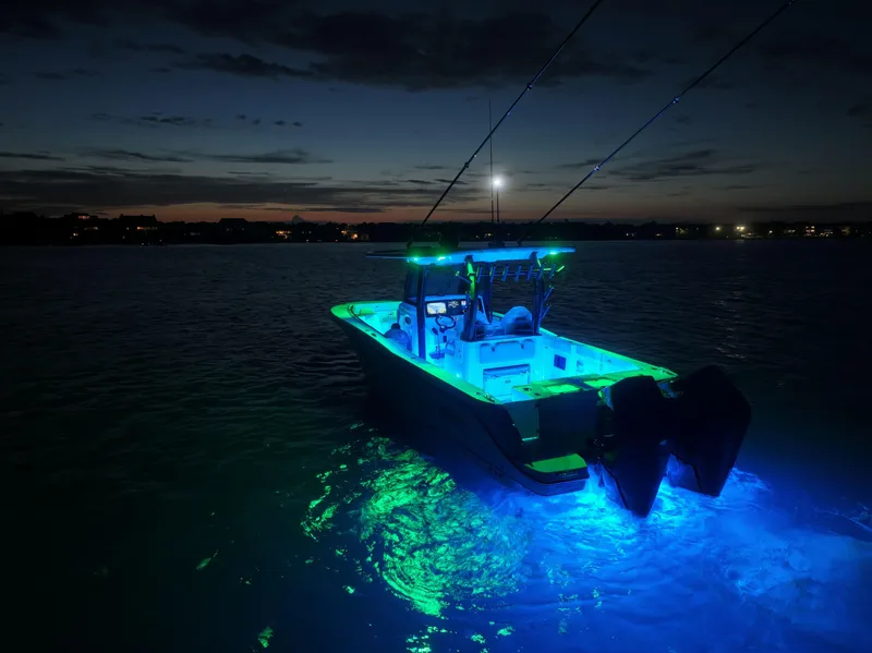 Slide: The Image of 2025 Crevalle 33 CSF boat illuminated at night on calm water. - 7