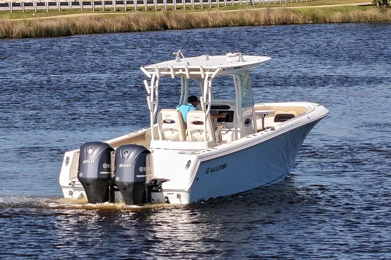 Slide: The Image of 2018 Sailfish 290 CC boat with dual engines cruising on a calm river. - 10