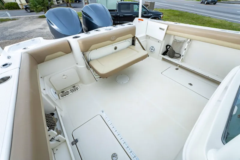 Slide: The Image of 2018 Sailfish 290 CC boat interior with beige seating and storage compartments. - 13