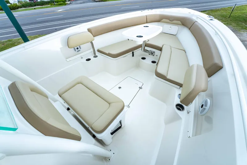 Slide: The Image of 2018 Sailfish 290 CC boat interior with beige seating and table. - 15