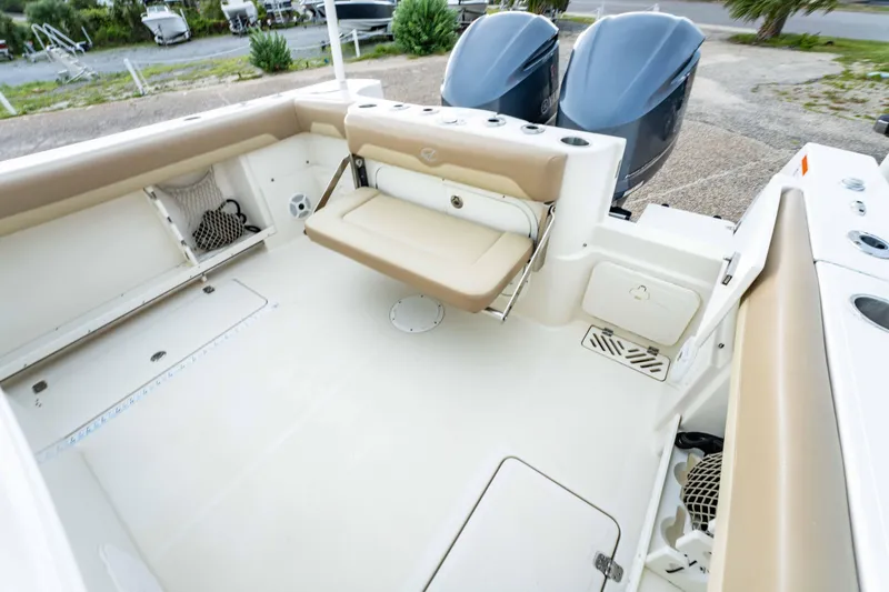 Slide: The Image of 2018 Sailfish 290 CC boat interior with beige seating and dual outboard motors. - 19