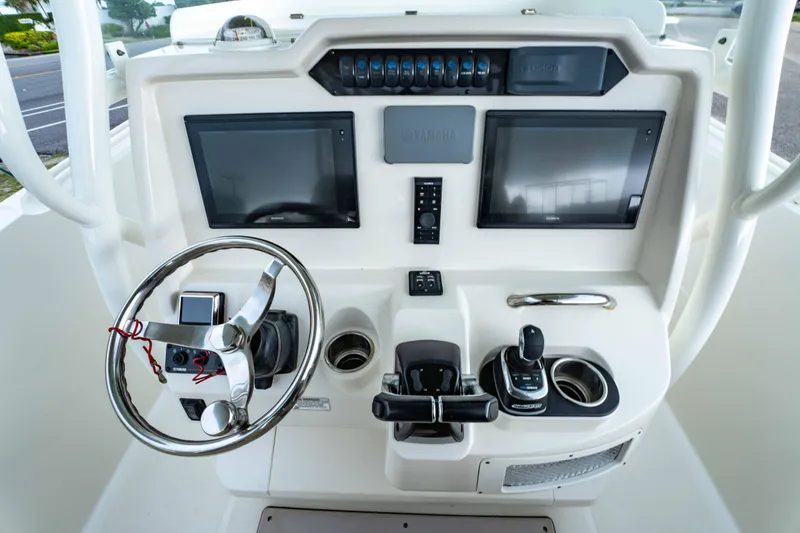 Slide: The Image of Control panel of 2018 Sailfish 290 CC boat with steering wheel and dual screens. - 25